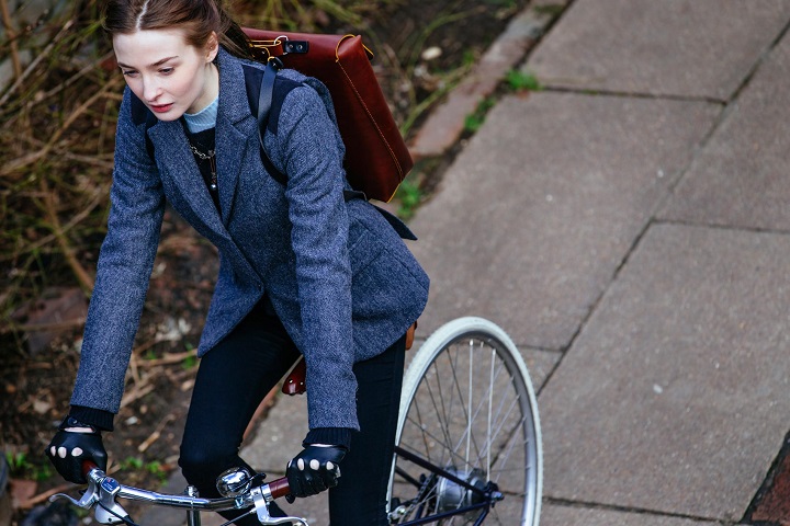 девушка в пиджаке на велосипеде